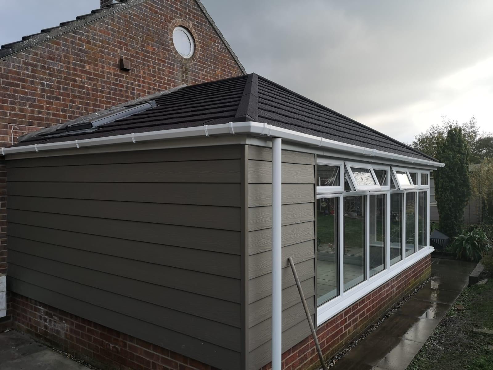 Tiled conservatory with wood panels and grey tiles
